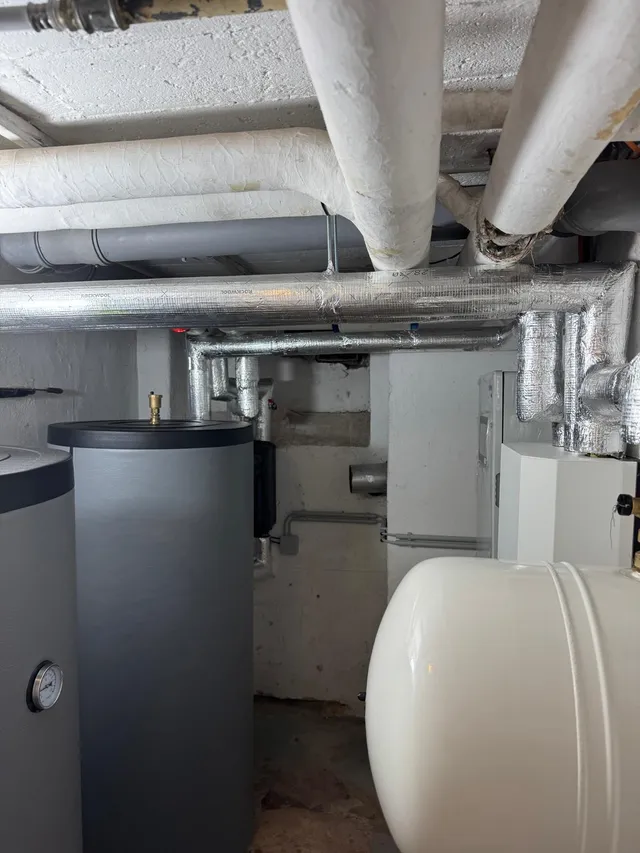 Technikraum mit Pufferspeicher und gedämmter Rohrleitung der neuen Wärmepumpenanlage